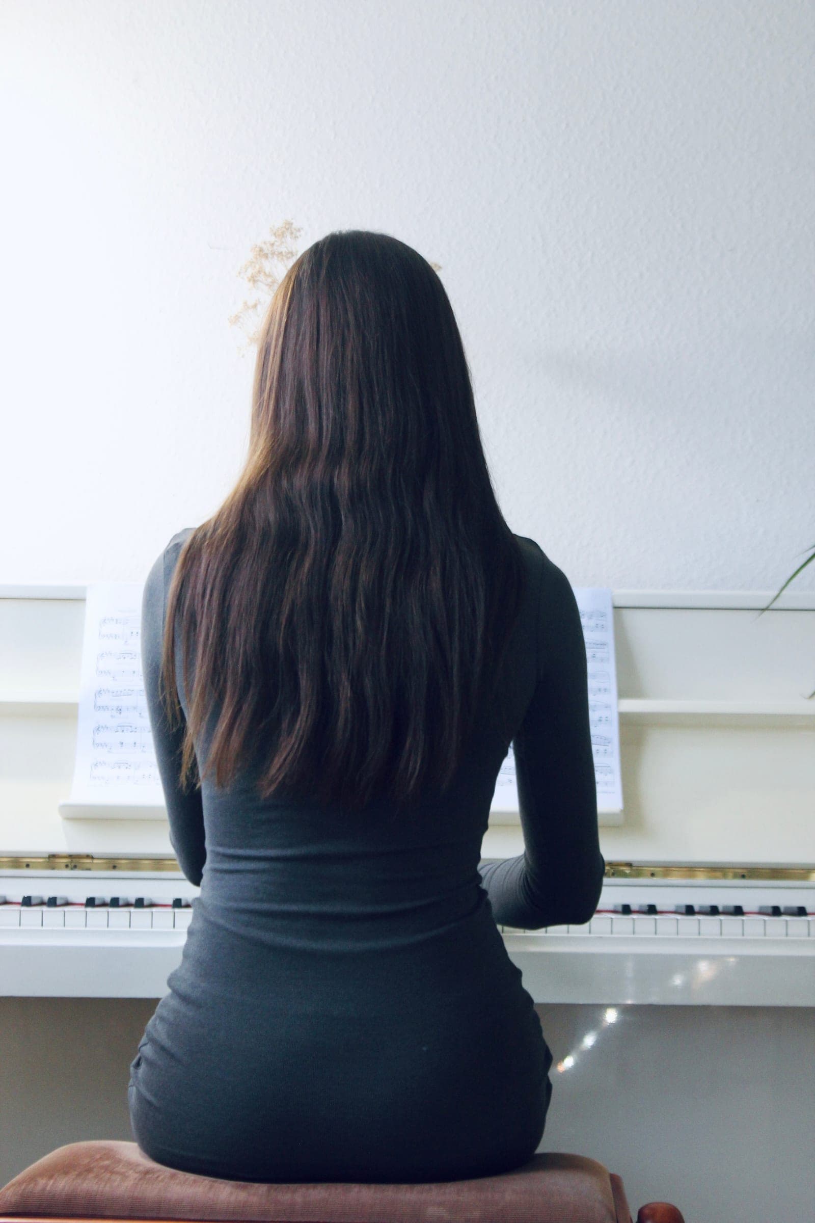 Ceren sitting at the piano in her teaching studio
